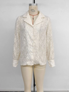 Detail of white long sleeve shirt showing textured feather fringe and white buttons