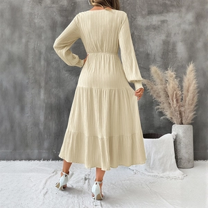 Chic beige V-neck layered long sleeve midi dress with textured fabric seen from the back