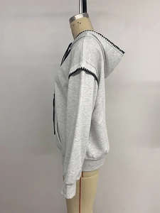 Detail of grey hoodie showing black contrast stitching and decorative wavy seam edges