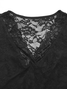 Close-up of fine black floral lace stitching on the V-neckline of a women's top