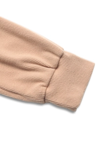 Close-up of ribbed texture and elastic cuffs on a light pink beige hoodie sweatshirt