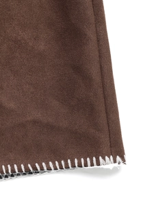 Detailaufnahme der Kontrastnaht am Saum der dunkelbraunen Wildlederjacke mit Textur