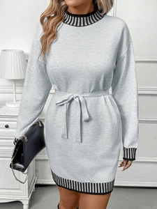Detail of grey knit dress featuring high neck striped trim and waist tie belt