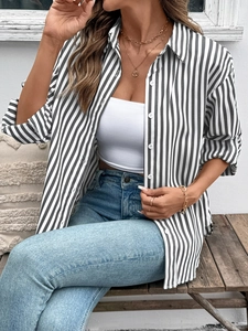 Detailed view of women's black and white striped long sleeve shirt with white buttons
