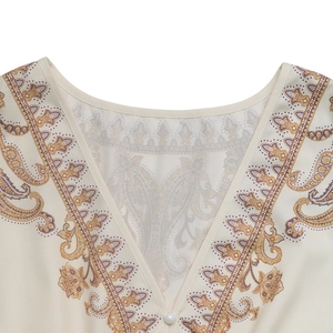 Détail d'un col en V élégant avec motif paisley et bouton en perle décoratif