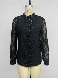 Detail of floral lace sleeves and eyelet embroidery on a black long-sleeved shirt