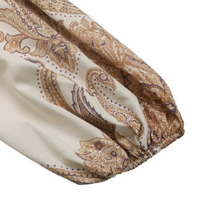 Détail de la manche lanterne à imprimé paisley et poignet élastique sur robe crème