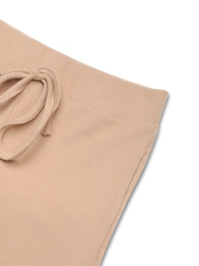 Detail of beige ribbed knit fabric with elastic waistband and drawstring for comfort