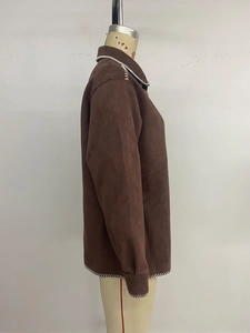 Detail einer braunen Wildlederimitat-Jacke mit weißen Zierstichen an den Kanten
