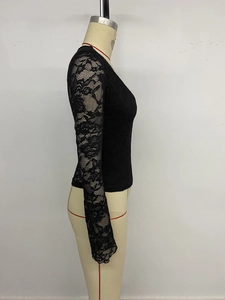 Close-up of black lace long sleeve top with intricate floral pattern and sheer mesh texture