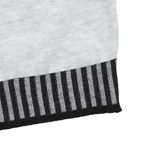 Detailed view of the light grey knitted fabric with black striped ribbed cuffs