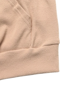 Close-up of ribbed texture and stitched pocket detail on a pink hooded sweatshirt