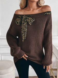 Detail of dark brown off-shoulder knit sweater with a leopard print bow accent