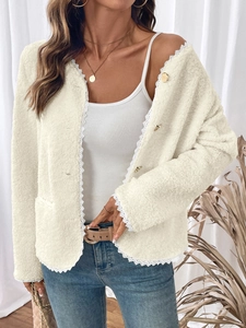 Details von Spitze und Goldknöpfen an einer warmen beigefarbenen Fleecejacke für Damen