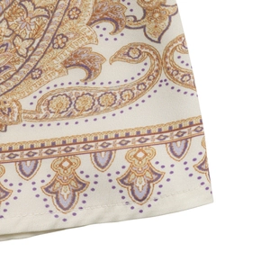 Gros plan sur le tissu à imprimé paisley jaune et violet d'une robe bohème élégante