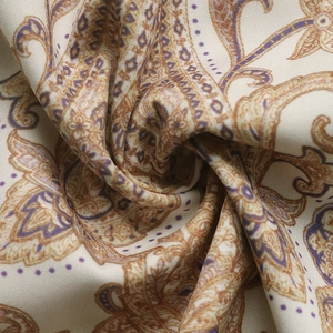 Détail macro du motif cachemire élégant sur tissu crème doux avec des motifs vintage