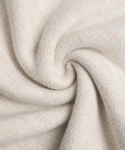Macro shot of soft cream knit sweater material showing fluffy texture and fine stitching