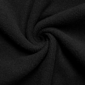 Vue macro du tricot côtelé noir montrant la texture brossée douce et les détails du tissu
