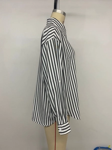 Detail of classic black and white vertical stripe long sleeve shirt cuff and fabric texture