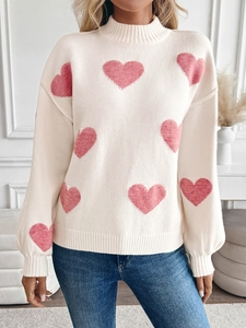 Detail of pink heart jacquard knit texture and ribbed mock neck on cream sweater