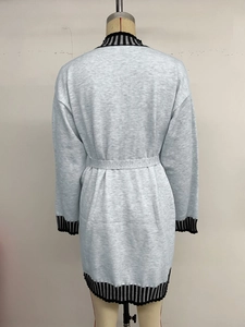 Detail view of the back of a grey striped knit midi dress with striped cuffs and waist belt