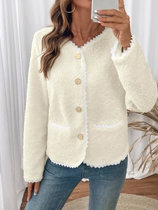 Detail der cremefarbenen Fleece-Strickjacke mit Spitzenbesatz und goldfarbenen Knöpfen