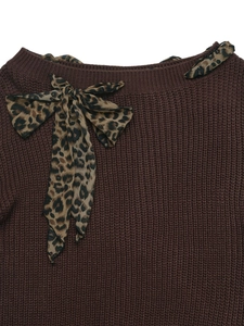Detailed close-up of brown knit sweater featuring a leopard print satin bow neckline