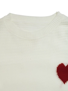 Close-up of ribbed crewneck and red heart pattern on white knit sweater top