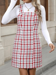 Detail of red and white plaid tweed pinafore dress with white high-neck ribbed long sleeve top