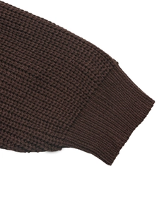 Close-up of thick honeycomb knit texture and ribbed cuffs on a brown sweater