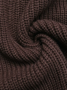 Detailed macro view of the thick dark brown knit fabric with 3D waffle texture