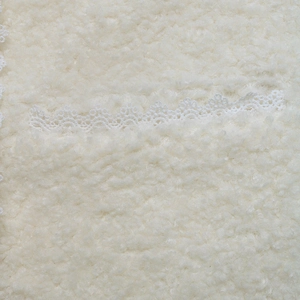 Detailansicht der weißen Teddy-Fleece-Struktur mit filigranem Spitzenbesatz an der Jacke