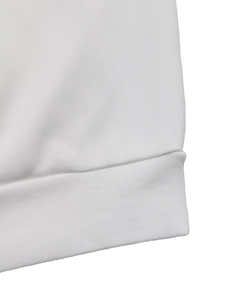 Detailed close-up of white striped sweatshirt ribbed cuff and premium cotton fabric texture