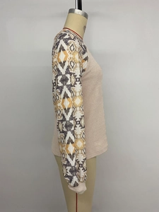Détail du tissu gaufré et des manches à motifs ethniques géométriques sur ce haut