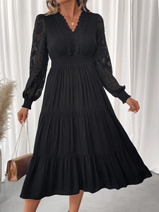 Détails du col en V avec dentelle florale et manches longues transparentes sur une robe noire