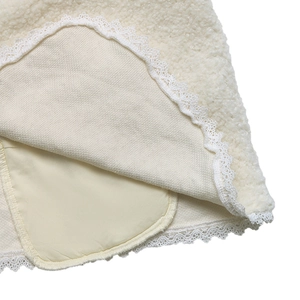 Detail aus weichem Teddyfell-Stoff mit zarter weißer Spitze und sauberem Innenfutter
