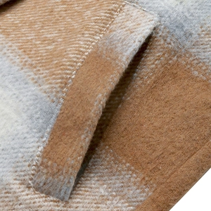 Close-up of the side pocket and textured plaid wool fabric on a women's vintage coat