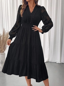 Détail du décolleté en V élégant avec dentelle et manches transparentes sur la robe noire