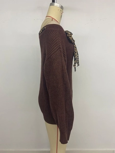 Detail of dark brown knit sweater with long sleeves and leopard print ribbon bow