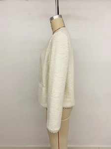 Detail der cremefarbenen Teddy-Fleecejacke mit feiner Spitze an Ärmeln und Saumkante