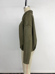 Détail de veste en daim olive avec des pattes d'épaule rétro et des manches amples