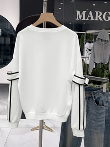 Close-up of the back of a white long-sleeve sweatshirt with black vertical stripe details