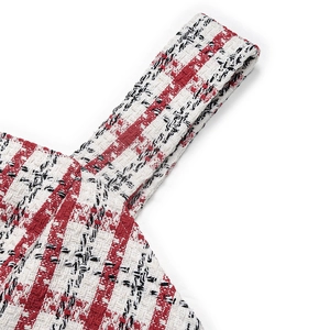 Macro view of the red and black plaid tweed fabric texture on a vintage dress strap