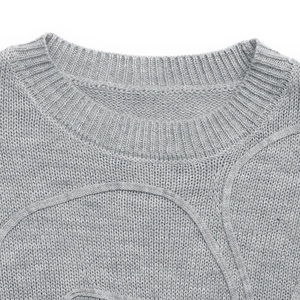 Detail of gray knit sweater showing ribbed crew neck and textured stitching pattern