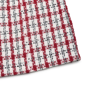 Close-up of red and white tweed plaid fabric with detailed weave for autumn dress