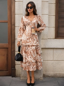 Detail of V-neck printed dress with tiered ruffle hem and abstract brown pattern
