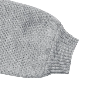 Close-up of gray knitted sweater sleeve with ribbed cuff and fine stitch texture