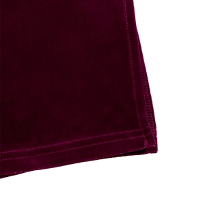 Dettaglio doppia cucitura sull'orlo di velluto bordeaux di un vestito elegante