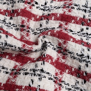 Detail of red and black houndstooth tweed fabric showing premium woven texture and thickness