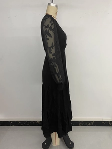 Detail of elegant black dress showing sheer floral embroidered sleeves and layered skirt